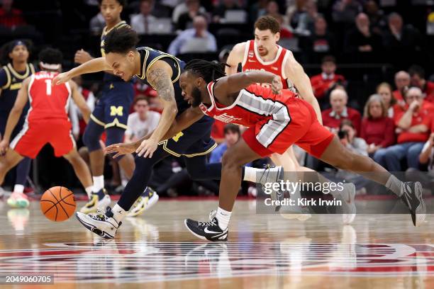 Bruce Thornton of the Ohio State Buckeyes and Terrance Williams II of the Michigan Wolverines chase after a loose ball during the first half of the...