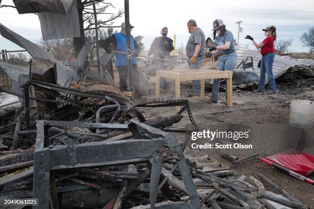 Members of Charles Clark's family sift through debris of his garage searching for salvageable items in the aftermath of the Smokehouse Creek fire on...