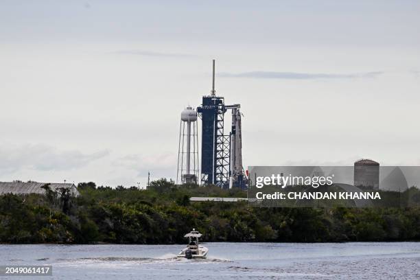 Kennedy Space Center Police patrol in a boat as the SpaceX Falcon 9 rocket with the Crew Dragon Endeavour capsule sits on launch pad LC-39A at...