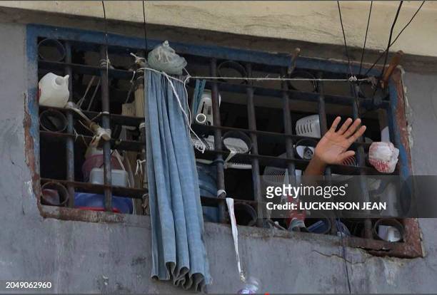 This screen grab taken from AFPTV shows a person waving his hand from a cell inside the main prison of Port-au-Prince, Haiti, on March 3 after a...