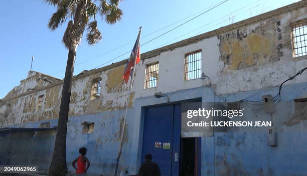 This screen grab taken from AFPTV shows people looking at the building of the main prison of Port-au-Prince, Haiti, on March 3 after a breakout by...