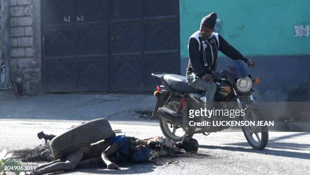 Graphic content / This screen grab taken from AFPTV shows a man looking at bodies near the main prison of Port-au-Prince, Haiti, on March 3, 2024...