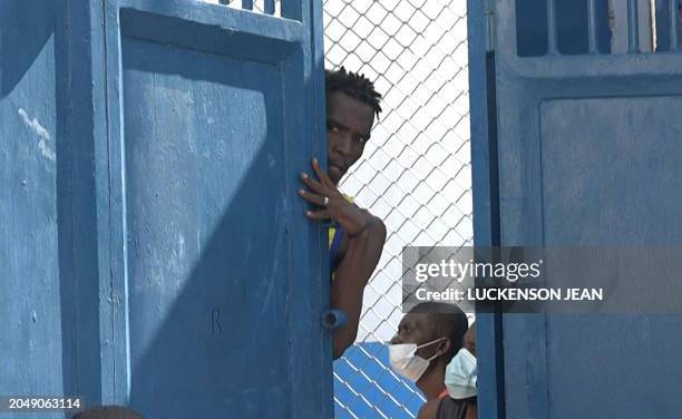 This screen grab taken from AFPTV shows a person looking out from behind a door near the main prison of Port-au-Prince, Haiti, on March 3 after a...