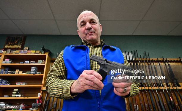 Patrick Jones, Shasta County supervisor and gun shop owner, displays a Sig Sauer Pistol on February 24, 2024 in Redding in Northern Califonia's...