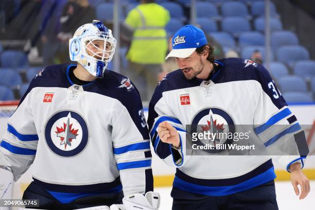 Laurent Brossoit of the Winnipeg Jets is congratulated by Connor Hellebuyck following their 5-2 victory against the Buffalo Sabres following an NHL...
