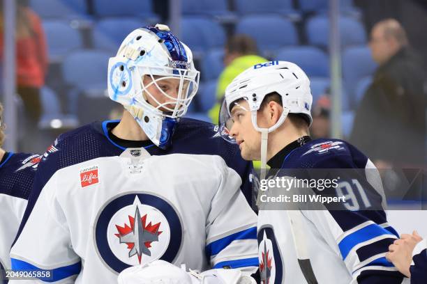 Laurent Brossoit of the Winnipeg Jets is congratulated by Cole Perfetti following their 5-2 victory against the Buffalo Sabres during an NHL game on...