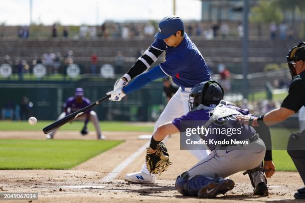 Shohei Ohtani of the Los Angeles Dodgers hits a single in the first inning of a spring training game against the Colorado Rockies in Glendale,...