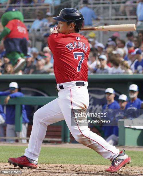 Masataka Yoshida of the Boston Red Sox hits an RBI single in the sixth inning of a spring training baseball game against the Toronto Blue Jays in...