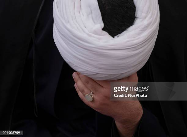 An Iranian cleric is mourning while attending a farewell ceremony with the body of Senior conservative Iranian cleric and member of the Assembly of...