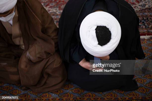 An Iranian cleric is using his cellphone while attending a farewell ceremony for the body of Senior conservative Iranian cleric and member of the...