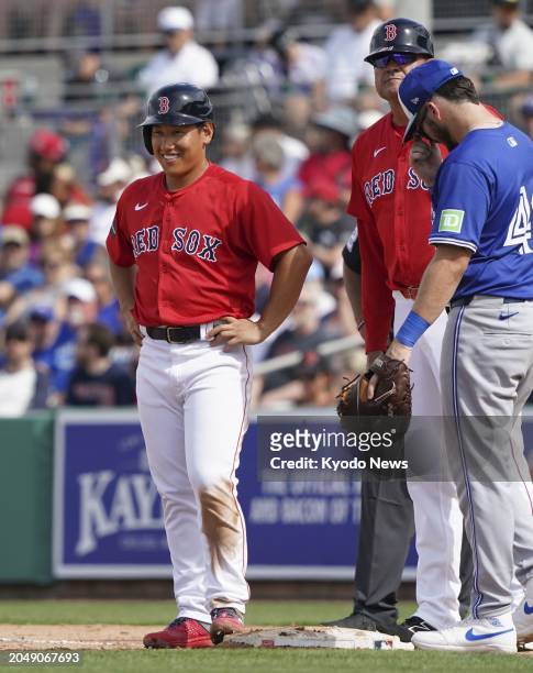 Masataka Yoshida of the Boston Red Sox smiles on first base after hitting an RBI single in the sixth inning of a spring training baseball game...