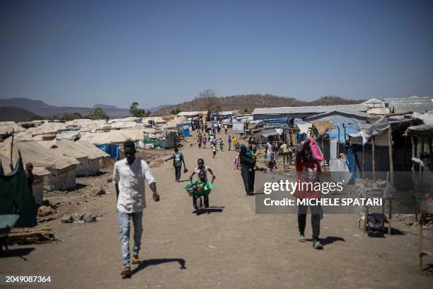 People walks along the main road of Kumer refugee camp, near Maganan, 70 km from the Sudanese border in Ethiopia's Amhara region, on February 29,...