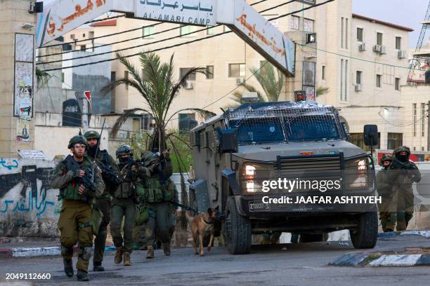 Israeli troops approach a roundabout during a raid on the Al-Amari refugee camp near Ramallah, in the occupied West Bank, on March 4, 2024.