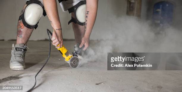 widening cracks in basement floor with angle grinder for waterproofing. in the course of this work a lot of dust is produced. - stamped concrete stockfoto's en -beelden