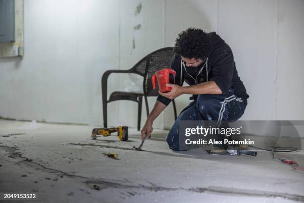 worker using hydraulic cement to waterproof the cracks in the basement floor. - stamped concrete stockfoto's en -beelden