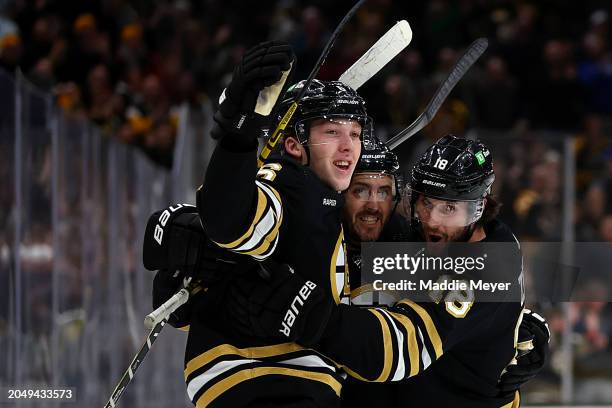 Mason Lohrei of the Boston Bruins celebrates with Kevin Shattenkirk and Pavel Zacha after scoring the game winning goal against the Vegas Golden...