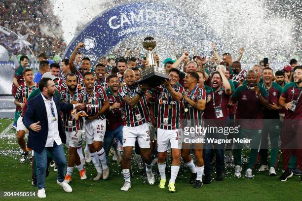 German Cano and Felipe Melo of Fluminense lift the trophy with teammates after winning the Recopa Sudamericana 2024 second leg match between...