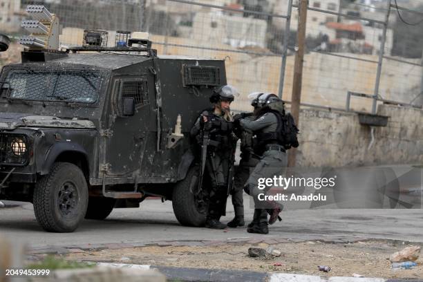 An Israeli officer injured in her foot, escorted away by her colleagues during their raid on al-Amari Refugee Camp in Ramallah, West Bank on March 4,...