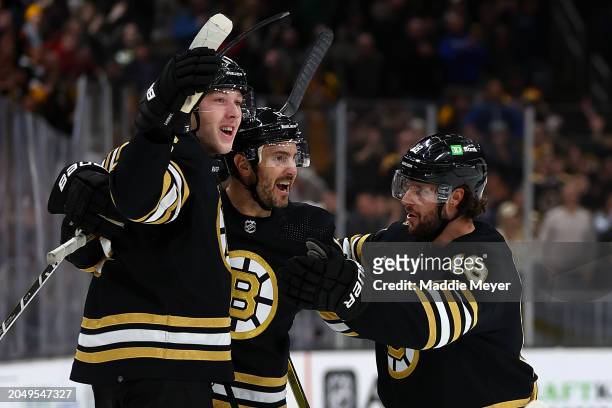 Mason Lohrei of the Boston Bruins celebrates with Kevin Shattenkirk and Pavel Zacha after scoring the game winning goal against the Vegas Golden...