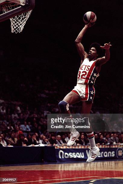 Julius Erving of the New York Nets soars to the basket during an ABA game at the Nassau Veterans Memorial Coliseum in 1974 in Uniondale, New York....