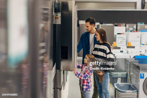 satisfied customers choosing fridge in domestic appliances section - mom fridge stock pictures, royalty-free photos & images