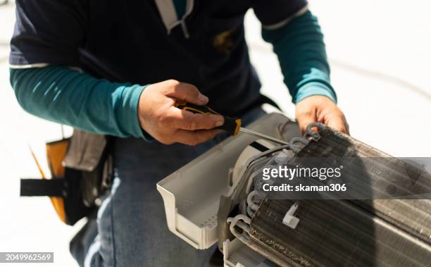 hand of mechanic man remove  system and part of air condition for hard cleaning at home - air cooler stock pictures, royalty-free photos & images