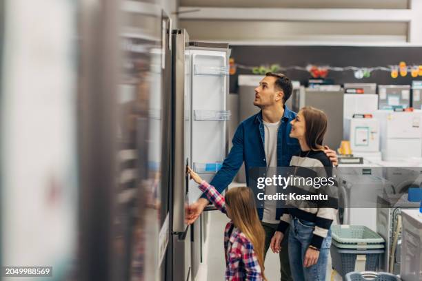 a family chooses appliances for their home in wholesale, in the home appliance section - refrigerator stock pictures, royalty-free photos & images
