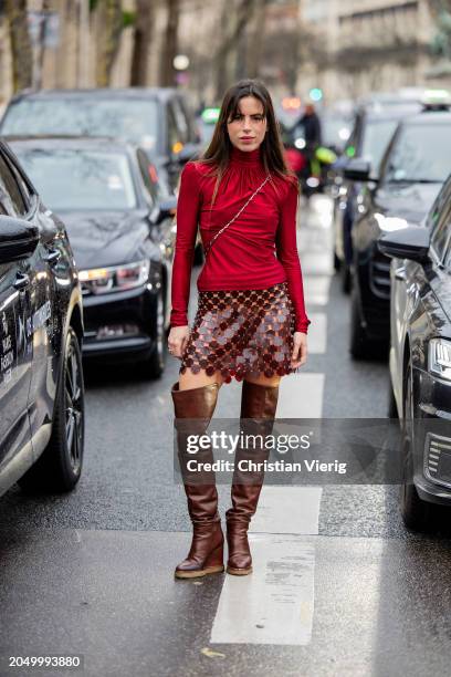 Nina Urgell Cloquell wears red long skirt, net skirt, brown over knees boots outside Paco Rabanne during the Womenswear Fall/Winter 2024/2025 as part...