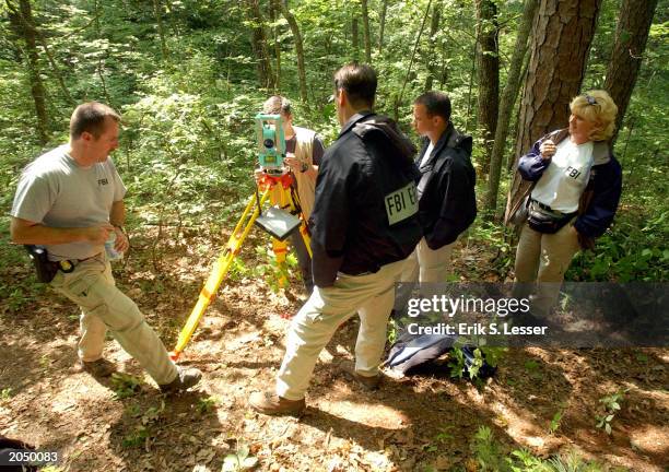 An FBI evidence team surveys a campsite allegedly used by serial bombing suspect Eric Robert Rudolph June 2, 2003 in the woods outside Murphy, North...