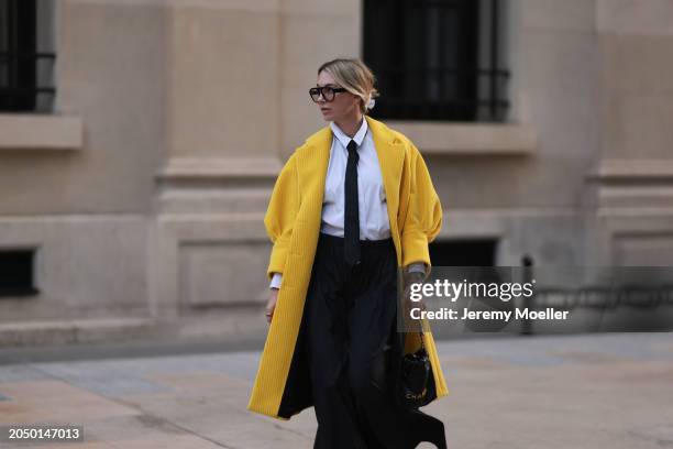 Karin Teigl seen wearing Andy Wolf black glasses, Comma white cotton buttoned shirt, H&M black tie, Prada yellow corduroy long coat, H&M Studios...