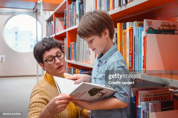 mother and son at the public library - books in library stock pictures, royalty-free photos & images