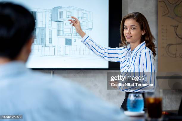 managing your design projects process to ensure compliance. a female designer is discussing construction projects design with her team on a display lcd to ensure compliance in a modern office. - flexible screen stock pictures, royalty-free photos & images