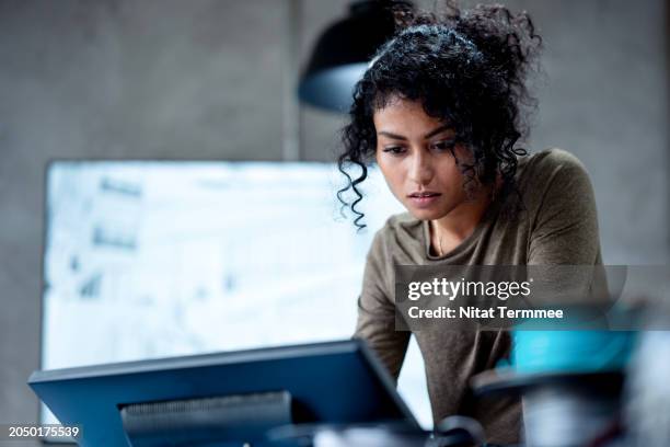 a sustainable design to driven of an energy efficient building. a female construction designer on a project design for optimum energy efficiency via a computer in a modern design office. - risikomanagement stock-fotos und bilder
