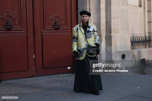 Karin Teigl seen wearing H&M black baret hat, H&M Studios black blouse / shirt, Stine Goya blue / green metallic print pattern blazer jacket, H&M...