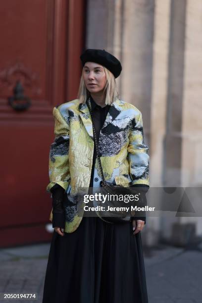 Karin Teigl seen wearing H&M black baret hat, H&M Studios black blouse / shirt, Stine Goya blue / green metallic print pattern blazer jacket, H&M...