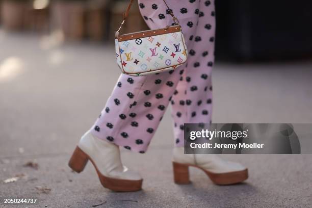 Karin Teigl seen wearing Stine Goya pink with black flower print pattern long pants, Louis Vuitton Pochette white leather multicolor logo print...