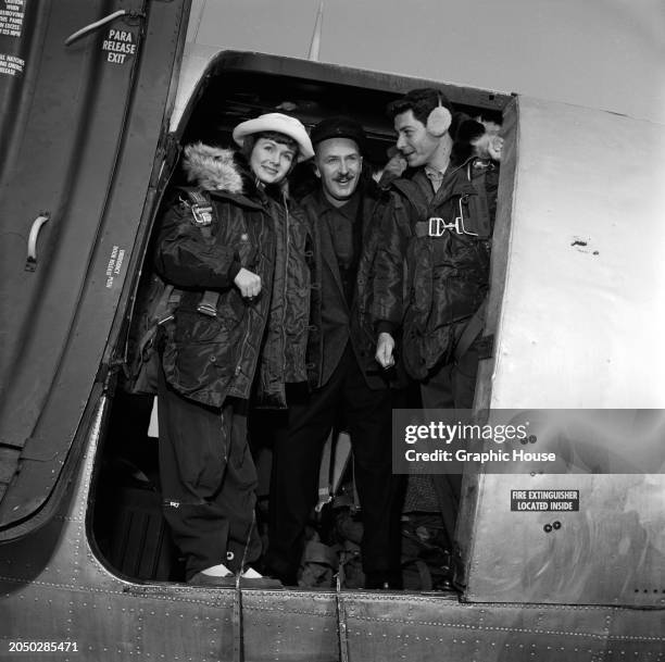 American actress and singer Debbie Reynolds and her husband, American actor and singer Eddie Fisher, both wearing fur-trimmed flight jackets, stand...