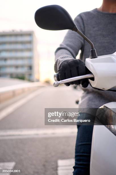 unrecognizable male biker stopped in the traffic light at the city street. copy space. - motorcycle throttle stock pictures, royalty-free photos & images