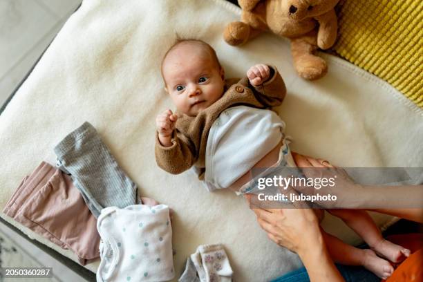baby having his nappy changed - changing diaper stock pictures, royalty-free photos & images