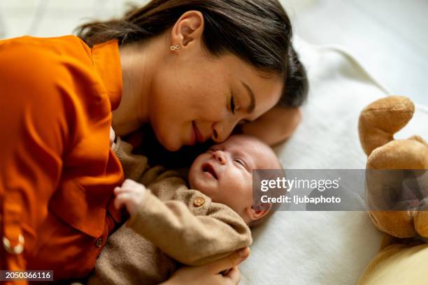 young mother and baby napping at home - hug sleep woman stock pictures, royalty-free photos & images