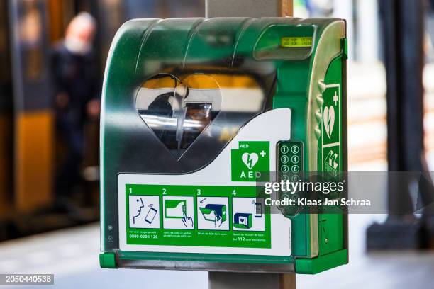 desfibrilador aed en armario con símbolo blanco verde - desfibrilador fotografías e imágenes de stock
