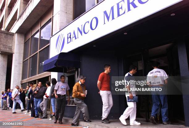 Bank clients wait in line in front of a bank in Caracas, 12 December, 2002. The embattled Venezuelan President Hugo Chavez rejected opposition calls...