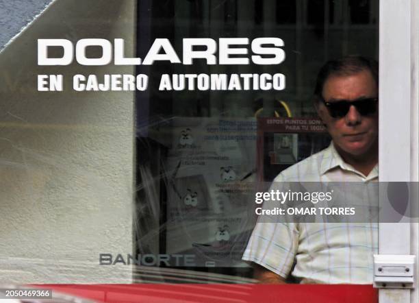 Man uses an ATM exclusively for American currency, 15 June 2001, Mexico City. Un hombre sale de un cajero automatico exclusivo para dolares, el 15 de...