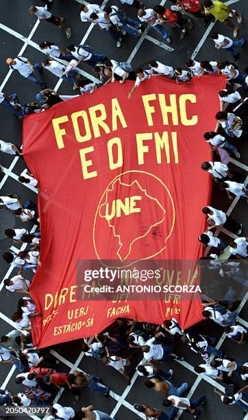 Students carry a flag demanding the resignation of the President of Brazil and the end of the interference of the International Monetary Fund, 7 June...