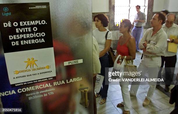 Clients of Light/EDF stand in line, 04 June 2001, to seek advice on how to follow the government's regulations of a 20% cut in the consumption of...