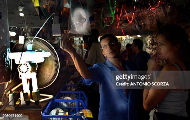 Salesman shows fluorescent lamps to a customer, 04 June 2001, in a store of electrical goods in Rio de Janeiro, Brazil. Un vendedor exhibe lamparas...
