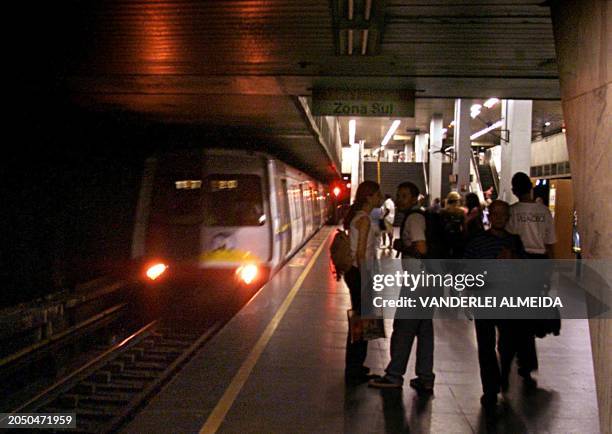 Passengers await the arrival of a subway train in a station darkened in order to conserve energy, Rio de Janeiro, Brazil, 04 June 2001. The Brazilian...