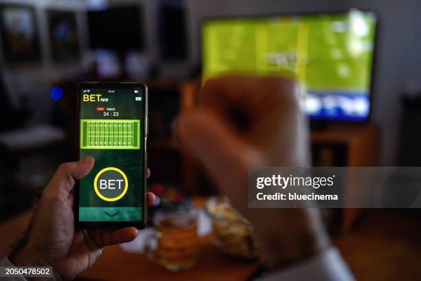mature men using smart phone for sports betting. - vrijetijd sport en spel stockfoto's en -beelden