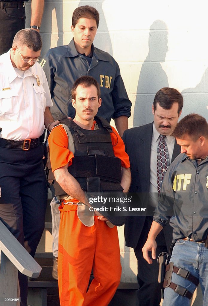 Bombing suspect Eric Robert Rudolph is escorted from the Cherokee ...