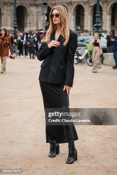 Toni Garrn wears black blazer, black long satin skirt, black boots, outside Off-White, during the Womenswear Fall/Winter 2024/2025 as part of Paris...